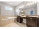 The primary bathroom has double vanity sinks, a large mirror, a soaking tub, and tiled floors at 3204 Mapleridge Dr, Lutz, FL 33558