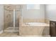 The primary bathroom has a standalone shower with glass doors and a tile surround soaking tub at 3204 Mapleridge Dr, Lutz, FL 33558
