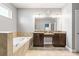 The primary bathroom has double vanity sinks, a large mirror, a soaking tub, and tile flooring at 3204 Mapleridge Dr, Lutz, FL 33558