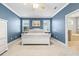 Inviting bedroom showcasing blue walls, a white bed frame, and an open doorway to the bathroom at 3204 Mapleridge Dr, Lutz, FL 33558