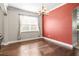 Dining room with hardwood floors, large windows, and a red accent wall at 3204 Mapleridge Dr, Lutz, FL 33558