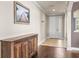 Hallway with tile and wood floors and view of entryway with white front door at 3204 Mapleridge Dr, Lutz, FL 33558