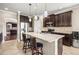 Bright kitchen featuring an island with granite countertops, stainless appliances, and dark cabinetry at 3204 Mapleridge Dr, Lutz, FL 33558