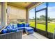 Relaxing screened patio featuring comfortable seating with blue cushions and scenic backyard water views at 3204 Mapleridge Dr, Lutz, FL 33558