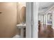 Charming pedestal sink powder room with wood floors and view to the front entry at 3204 Mapleridge Dr, Lutz, FL 33558