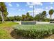 A view of a Cooper's Bayou Park sign surrounded by manicured shrubs and palm trees at 3351 San Jose St, Clearwater, FL 33759