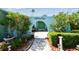 View of the entrance with a decorative archway, beautiful landscaping, and custom double front doors at 3351 San Jose St, Clearwater, FL 33759