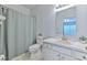 Clean bathroom featuring blue walls, tiled floors, vanity and shower with tub at 3456 High Hampton Cir, Tampa, FL 33610