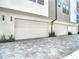 Exterior shot showing three garages with white doors and brick pavers in front of a modern home at 4215 W North A St # 3, Tampa, FL 33609