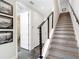 Hallway with stairs featuring a sleek metal railing, multiple doors, and framed art on the walls at 4215 W North A St # 3, Tampa, FL 33609