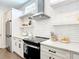 Contemporary kitchen featuring white cabinetry, a stainless steel range hood, and sleek appliances at 4215 W North A St # 3, Tampa, FL 33609