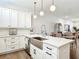 Bright, open kitchen with a stainless steel farmhouse sink, quartz countertops, pendant lighting, and an adjacent dining area at 4215 W North A St # 3, Tampa, FL 33609
