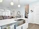 Open-concept kitchen featuring a stainless steel farmhouse sink, quartz countertops and island with barstool seating at 4215 W North A St # 3, Tampa, FL 33609