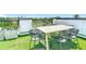 Charming rooftop deck boasts faux grass, city views and a modern table with seating for six at 4215 W North A St # 3, Tampa, FL 33609