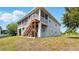 Exterior view showing the back of the house with a screened porch, stairs, and air conditioning units at 4396 5Th Isle Dr, Hernando Beach, FL 34607