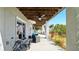 Covered patio featuring outdoor seating, ceiling fan, stairs to an upper-level balcony, and access to the yard at 4396 5Th Isle Dr, Hernando Beach, FL 34607