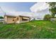 Spacious backyard with a chain link fence and partial view of the home's exterior at 4920 Zodiac Ave, Holiday, FL 34690
