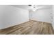 A well-lit room with hard wood floors, a ceiling fan and light, and an adjacent door at 4920 Zodiac Ave, Holiday, FL 34690
