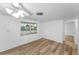 Bright bedroom features hardwood floors, a window, and a ceiling fan with light fixture at 4920 Zodiac Ave, Holiday, FL 34690