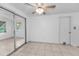 Tile-floored bedroom with ceiling fan, mirrored sliding doors, and neutral colored walls at 4920 Zodiac Ave, Holiday, FL 34690