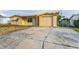 Charming single-story home featuring a light-colored exterior, attached garage, and a driveway at 4920 Zodiac Ave, Holiday, FL 34690