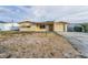 Charming single-story home featuring a light-colored exterior, attached garage, and gravel front yard at 4920 Zodiac Ave, Holiday, FL 34690