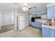 Corner view of a kitchen with blue cabinets, white tiled floor, and view to a bedroom at 4920 Zodiac Ave, Holiday, FL 34690