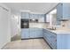 Traditional kitchen features blue cabinets, black appliances, and a tiled backsplash at 4920 Zodiac Ave, Holiday, FL 34690