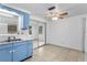 A kitchen with a double basin sink, blue cabinets, and view to another room with sliding glass door at 4920 Zodiac Ave, Holiday, FL 34690