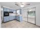 Spacious kitchen featuring blue cabinets, tiled floors, black appliances, and mirrored closet doors at 4920 Zodiac Ave, Holiday, FL 34690