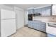 A classic kitchen with black appliances, vintage-style blue cabinets, and a white refrigerator at 4920 Zodiac Ave, Holiday, FL 34690