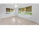 Bright living room features tile flooring, ceiling fan, and large windows overlooking the backyard at 4920 Zodiac Ave, Holiday, FL 34690