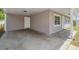 Covered carport featuring a side entry door and modern tiled walkway at 5111 Eldorado Dr, Tampa, FL 33615