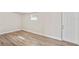 Simple bedroom featuring fresh paint, new floors, large window, and new door to the exterior at 5119 Gateway Dr, Tampa, FL 33615