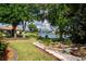 Large backyard with mature trees, landscaping, and a beautiful lake view at 603 Fort Duquesna Dr, Sun City Center, FL 33573