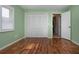 Bedroom with hardwood floors, window with wood trim, and closet space at 603 Fort Duquesna Dr, Sun City Center, FL 33573