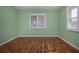 Bedroom with hardwood floors and large window with wood trim providing natural light at 603 Fort Duquesna Dr, Sun City Center, FL 33573