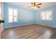 Bedroom features light blue walls, wood flooring, ceiling fan and bright natural lighting at 603 Fort Duquesna Dr, Sun City Center, FL 33573