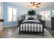 Charming bedroom features light blue walls, two windows, hardwood flooring, ceiling fan and modern furnishings at 603 Fort Duquesna Dr, Sun City Center, FL 33573