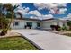 A spacious driveway with well-maintained landscaping, mature palm trees, and lovely curb appeal at 603 Fort Duquesna Dr, Sun City Center, FL 33573