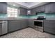 Updated kitchen features stainless steel appliances, gray cabinets, granite counters, and tile flooring at 603 Fort Duquesna Dr, Sun City Center, FL 33573