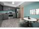 Kitchen with stainless steel appliances, gray cabinetry, light granite countertops and unique tile floors at 603 Fort Duquesna Dr, Sun City Center, FL 33573