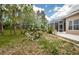 A landscaped backyard featuring a screened-in lanai at 617 Glastonbury Ct, Spring Hill, FL 34609