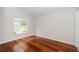 Bright bedroom features hardwood floors and a view of the outside through a large window at 617 Glastonbury Ct, Spring Hill, FL 34609