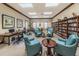 Cozy library with an extensive bookshelf, lounge chairs, and workspace at 617 Glastonbury Ct, Spring Hill, FL 34609
