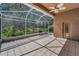 View of screened patio featuring tile flooring, ceiling fan, and a view of the lush green backyard at 617 Glastonbury Ct, Spring Hill, FL 34609