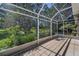 A screened-in patio with tile flooring and a view of the lush green lawn at 617 Glastonbury Ct, Spring Hill, FL 34609
