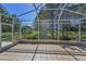 A screened-in patio with tile flooring and views of well-maintained lawns and shrubbery at 617 Glastonbury Ct, Spring Hill, FL 34609