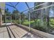 Screened-in patio with neutral-toned tile flooring overlooking the manicured lawn at 617 Glastonbury Ct, Spring Hill, FL 34609