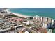 An aerial shot showcases the building's proximity to the beach, nearby tennis courts, and surrounding buildings at 7050 Sunset Way # 22, St Pete Beach, FL 33706